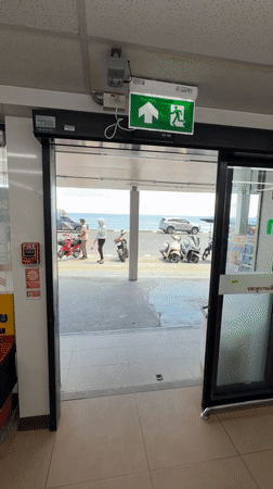 Slow morning on Patong Beach — surf, rocks, and a 7-Eleven run