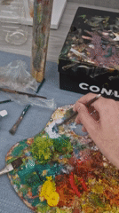 Artist observed painting with palette and supplies