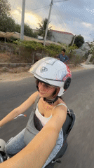 Woman rides motorbike through Mũi Né, Vietnam