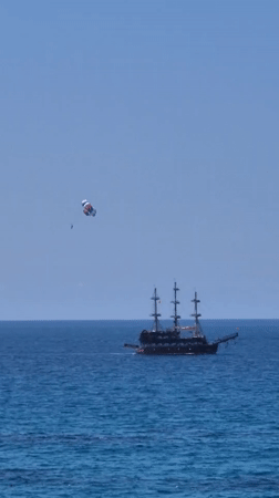 Parasailing and beach activities on calm ocean waters