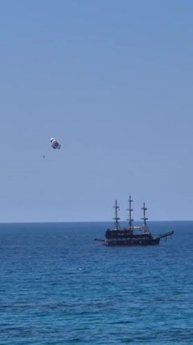 Parasailing and beach activities on calm ocean waters