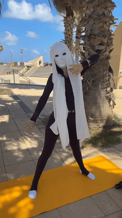 Masked person practices morning yoga in Netanya