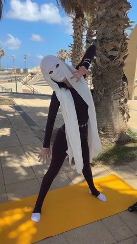 Masked person practices morning yoga in Netanya