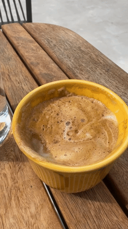 Woman enjoys morning coffee at Tivat waterfront establishment