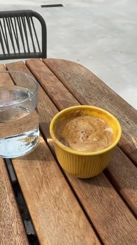 Woman enjoys morning coffee at Tivat waterfront establishment