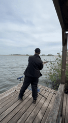 Angler spends afternoon fishing from wooden dock under cloudy skies