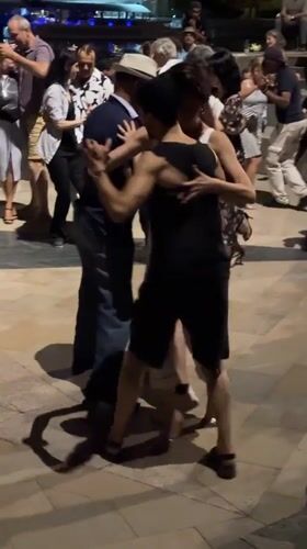 Tango and social dancing by a lit waterfront at night