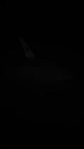 The video shows a dark scene with a faint, distant image of an airplane tail fin.