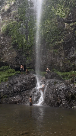 Visitors gather at scenic waterfall near temple in Budar, Nepal
