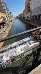 Milan canal filmed from padlock-covered bridge on sunny day