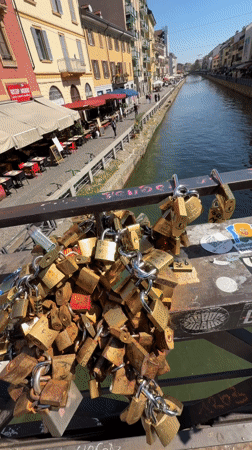 Milan canal filmed from padlock-covered bridge on sunny day