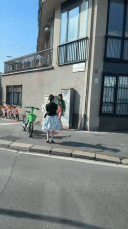 Two people gather on sunny Milano street corner