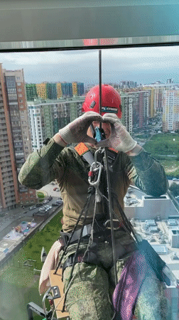 Worker performs rope access maintenance on Russian high-rise building