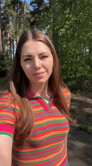 Woman documents morning forest walk near memorial in Раздолье