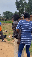 Young men play informal soccer match on dirt field in Riyom