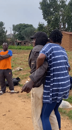 Young men play informal soccer match on dirt field in Riyom
