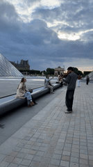 Daily life unfolds around Louvre: music, tourists, wedding party