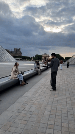Daily life unfolds around Louvre: music, tourists, wedding party