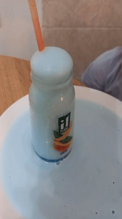 Child experiments with blue liquid during home cooking session