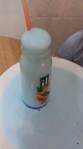 Child experiments with blue liquid during home cooking session