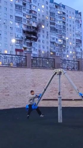 Children play near smoking apartment building in Nizhnevartovsk