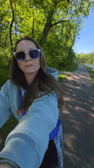 Woman cycles through Birobidzhan park with panda statues, Ferris wheel