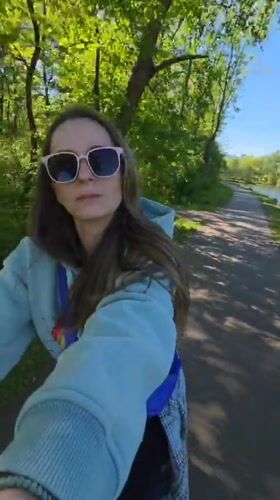 Woman cycles through Birobidzhan park with panda statues, Ferris wheel