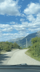 Vehicle travels curved mountain road in Kubasi, Montenegro