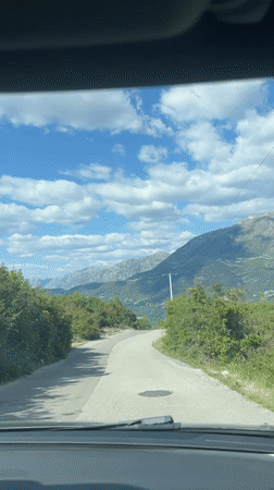 Vehicle travels curved mountain road in Kubasi, Montenegro