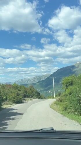 Vehicle travels curved mountain road in Kubasi, Montenegro