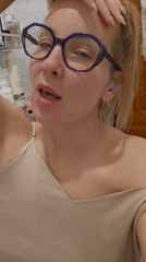 Woman photographed in bathroom wearing purple glasses in Sochi
