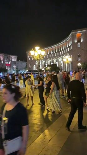 Evening gathering at an illuminated fountain square