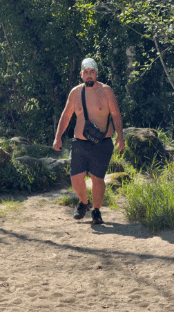 Young men gather in Portuguese woods, one wearing foil hat