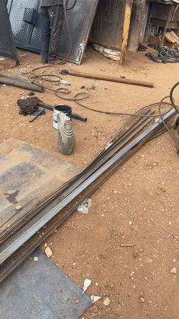 Construction workers load materials at Abuja metalworking depot