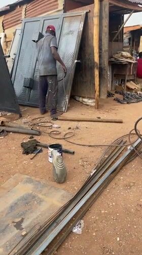 Construction workers load materials at Abuja metalworking depot