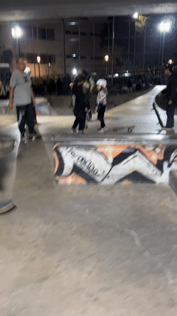 Skateboarder practices tricks at Buenos Aires skateparks during evening session