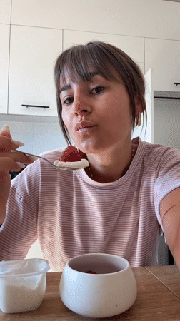 Woman enjoys yogurt breakfast in Cannes kitchen Sunday morning