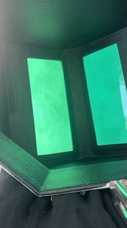 Boat moving along the Greek coastline, welding helmet close-up nearby