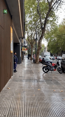 Uniformed man walks wet Buenos Aires streets during rainfall