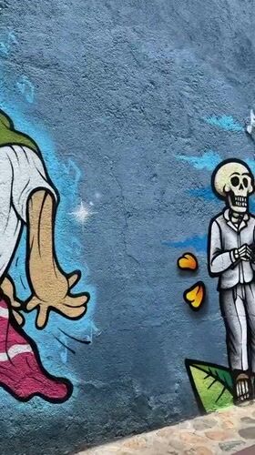 Tourist documents Day of Dead murals, colonial architecture in Oaxaca
