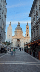 Pedestrians gather on cobblestone street near St. Stephen's Basilica