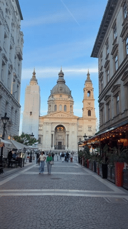 Pedestrians gather on cobblestone street near St. Stephen's Basilica