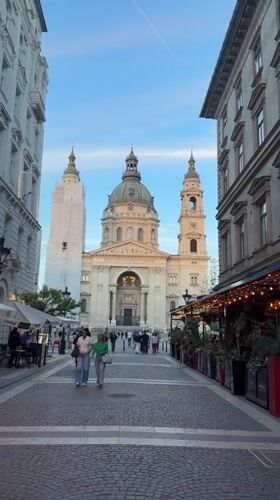 Pedestrians gather on cobblestone street near St. Stephen's Basilica