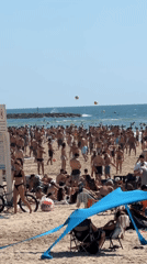 Crowded Tel Aviv beach busy with matkot players on sunny day