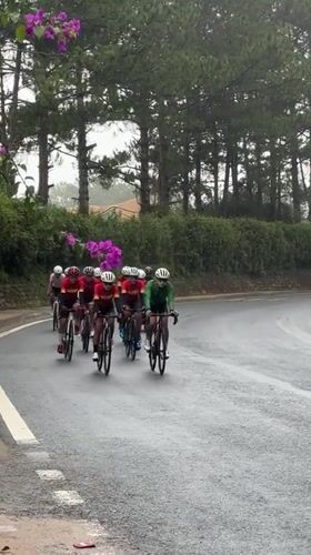 Cycling group rides through Da Lat's wet streets past ornate buildings