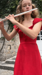 Blonde flutist performs in red dress in Budva