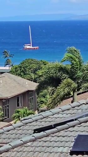 Sailboat spotted from Napili rooftop, white hull and red deck