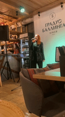 Red-haired woman performs at restaurant bar with Russian signage