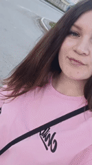 Woman films selfie video on Tobolsk street amid everyday pedestrian activity