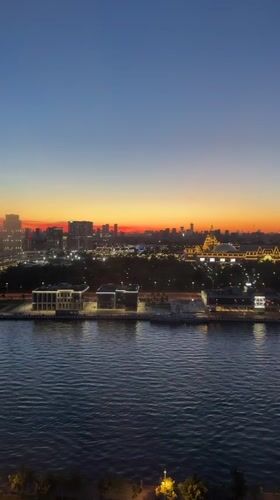 Moscow River skyline glows at dusk under a crescent moon